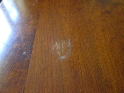 Damage from a hot plate placed on the table top without a trivet.